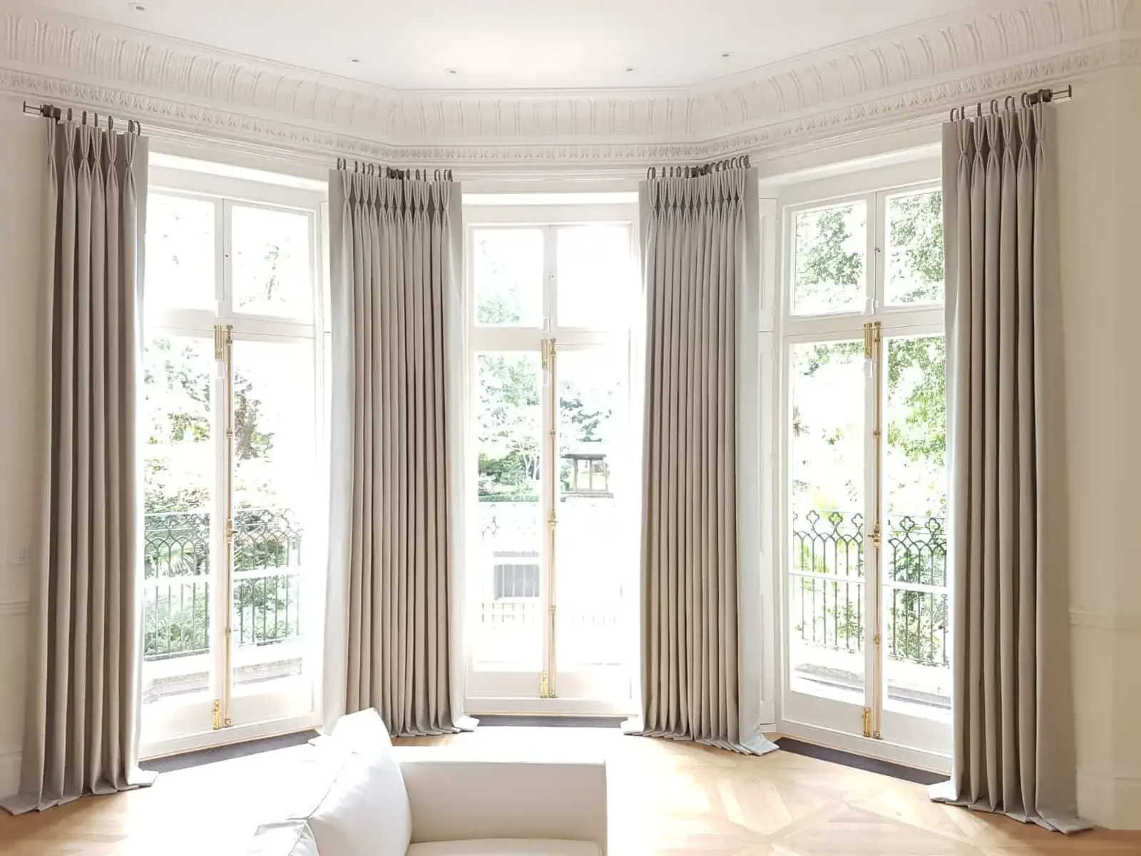 Full length curtains fitted around a large curved bay window