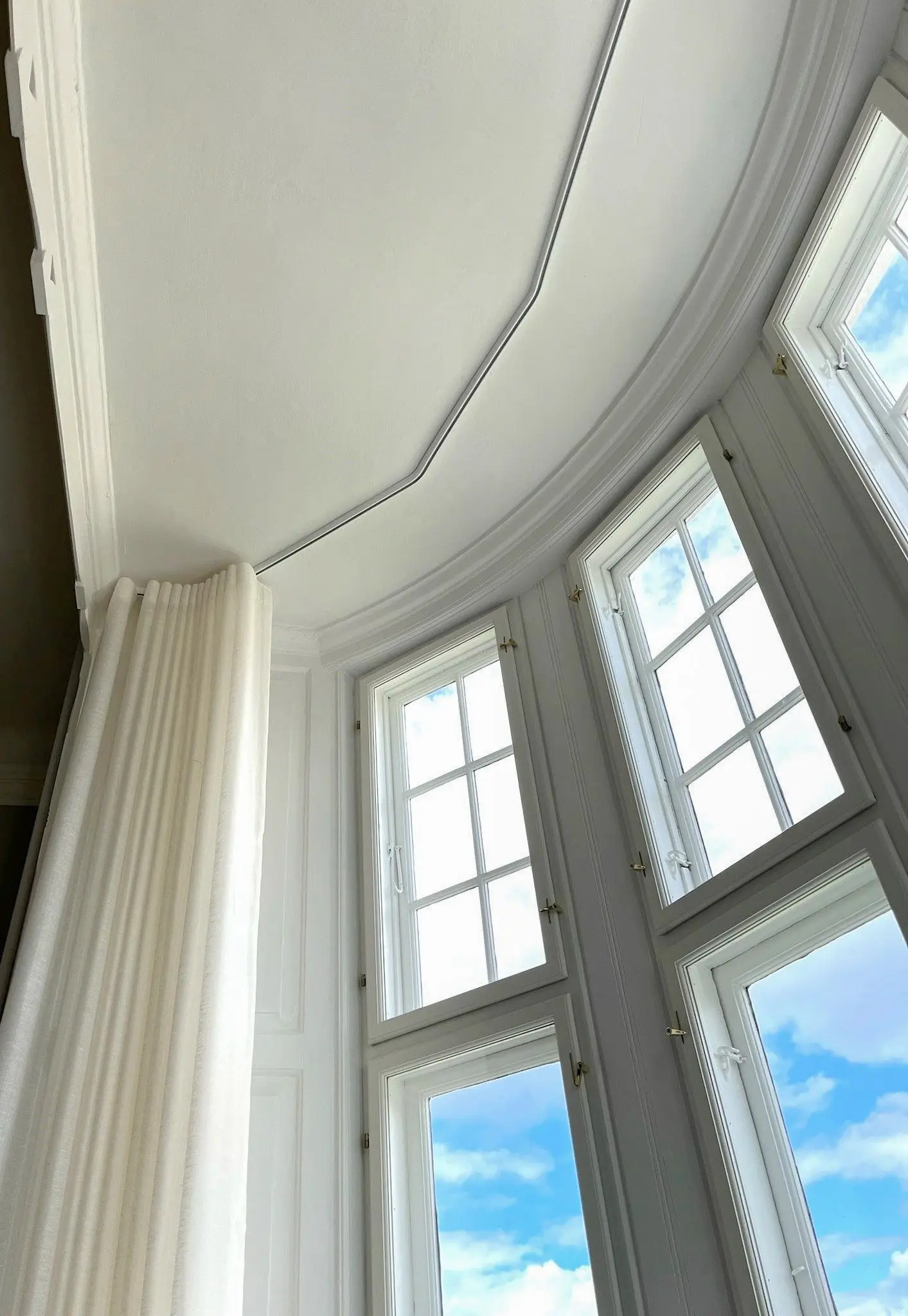 White curved curtain track mounted directly to a ceiling