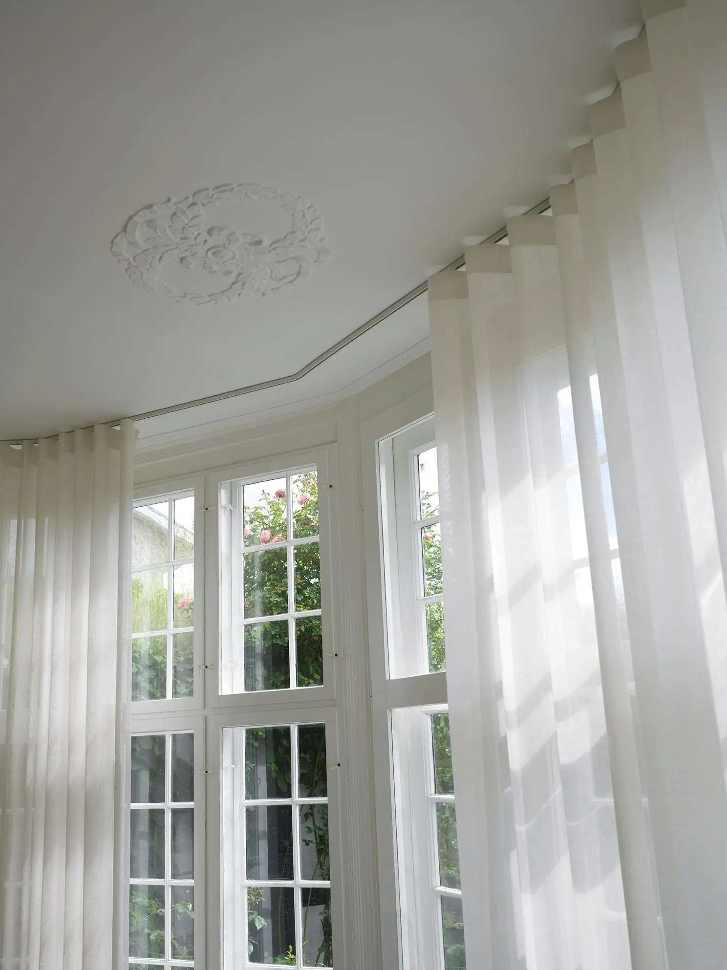 White wave pleat curtains following a curved ceiling track