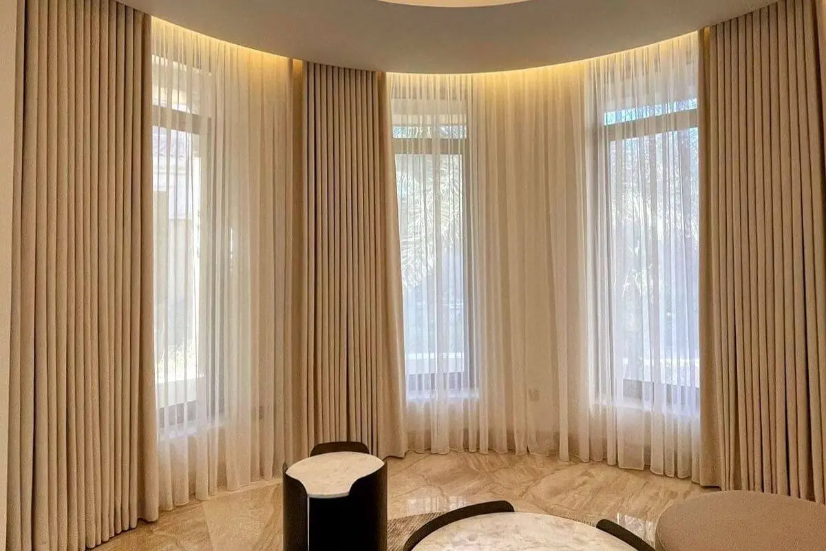 Sheer curtains fitted around a broad curved window