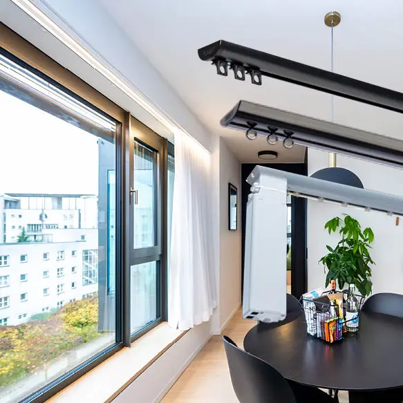 Discreet curtain track fitted above wide glazing in a modern dining space