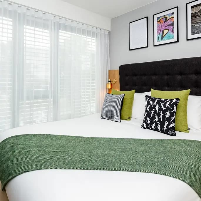 Layered curtains and voiles fitted across a contemporary bedroom window